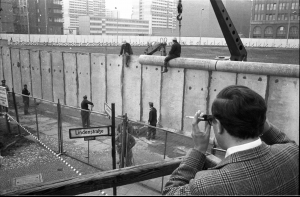 Foto: Ein Besucher einer Aussichtsplattform fotografiert das Anbringen der Rohrauflage auf die Grenzmauer 75 an der Zimmerstraße