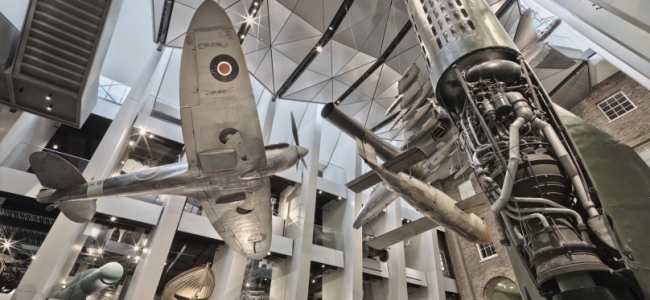 Photo: Atrium of the IWM London, the exhibits include a Supermarine Spitfire, a V-1 flying bomb, a V-2 rocket, a Harrier Jump Jet, by Imperial War Museums (IWM)